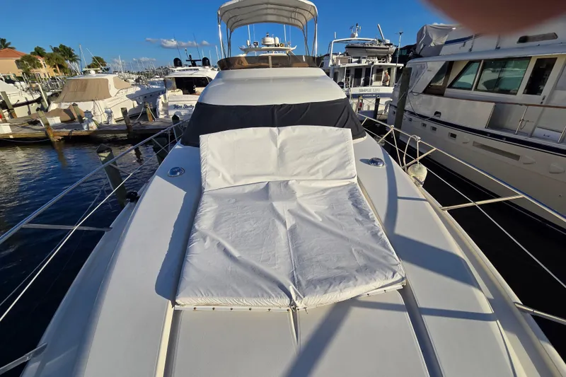 Slide: The Image of 1997 Sunseeker Manhattan 48 yacht with sunbed, docked at marina under clear blue sky. - 31