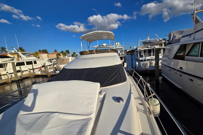 Slide: The Image of 1997 Sunseeker Manhattan 48 yacht docked at marina under clear blue sky. - 32