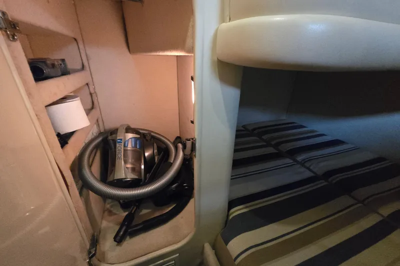Slide: The Image of Interior of 1997 Sunseeker Manhattan 48 yacht with striped bedding and storage area. - 64