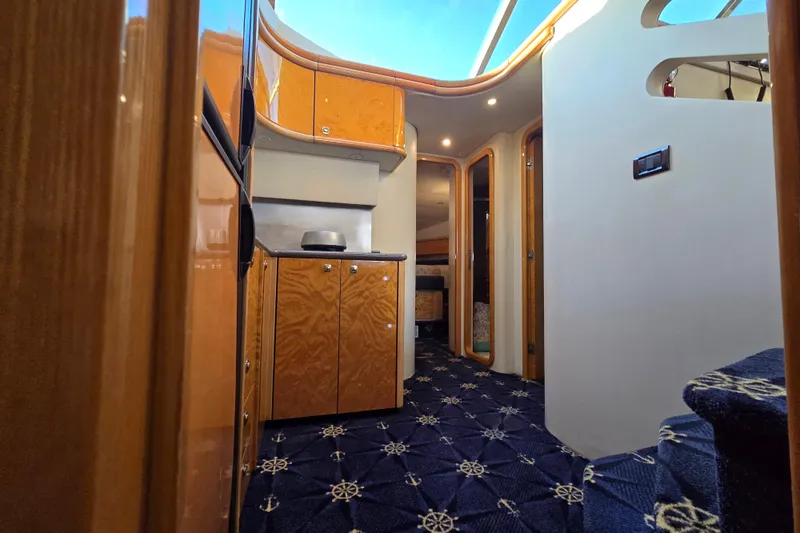 Slide: The Image of Interior of 1997 Sunseeker Manhattan 48 yacht with wooden cabinetry and nautical-themed carpet. - 65