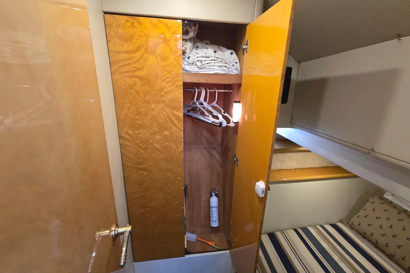 Slide: The Image of Sunseeker Manhattan 48 yacht interior, 1997, showing a wooden wardrobe with hangers and bedding. - 71