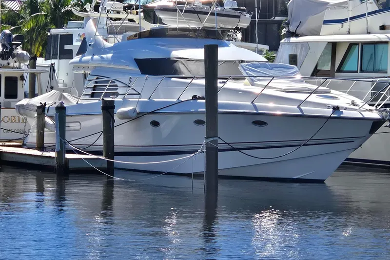 Slide: The Image of 1997 Sunseeker Manhattan 48 yacht docked in a marina, surrounded by other boats. - 8