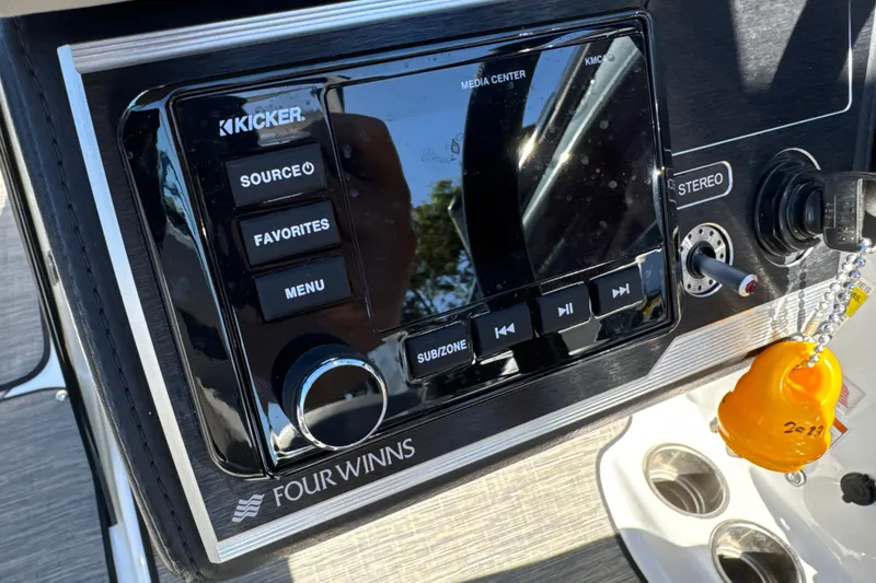 Slide: The Image of 2023 Four Winns HD5 OB boat dashboard with Kicker media center and ignition key. - 16