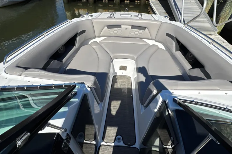 Slide: The Image of 2023 Four Winns HD5 OB boat interior with gray seating and open deck view. - 21
