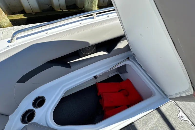 Slide: The Image of 2023 Four Winns HD5 OB boat storage compartment with red life jackets inside. - 27