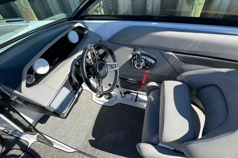 Slide: The Image of 2023 Four Winns HD5 OB boat interior with sleek steering and modern controls. - 9