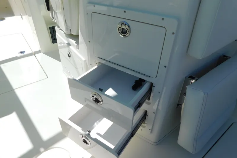 Slide: The Image of 2026 Cobia 240 Dual Console interior with storage compartments and seating. - 10