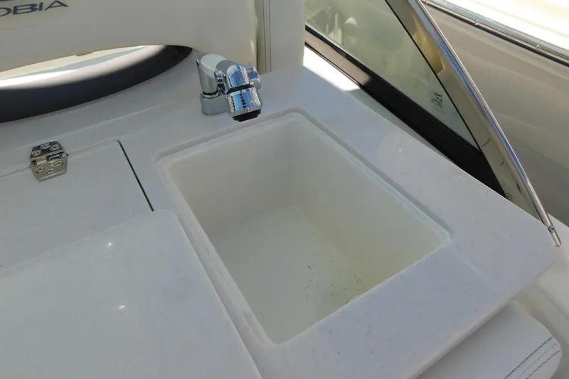 Slide: The Image of 2026 Cobia 240 Dual Console boat interior with white seating and storage compartments. - 13