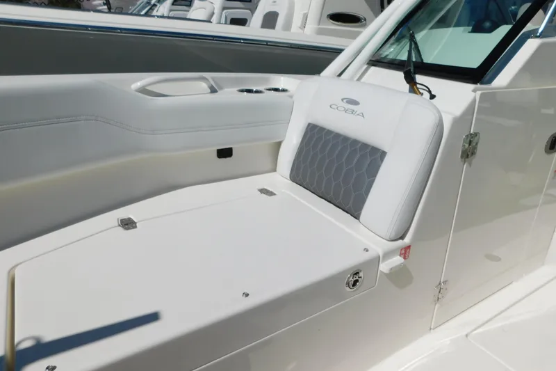 Slide: The Image of 2026 Cobia 240 Dual Console boat interior with cushioned seating and cup holders. - 23
