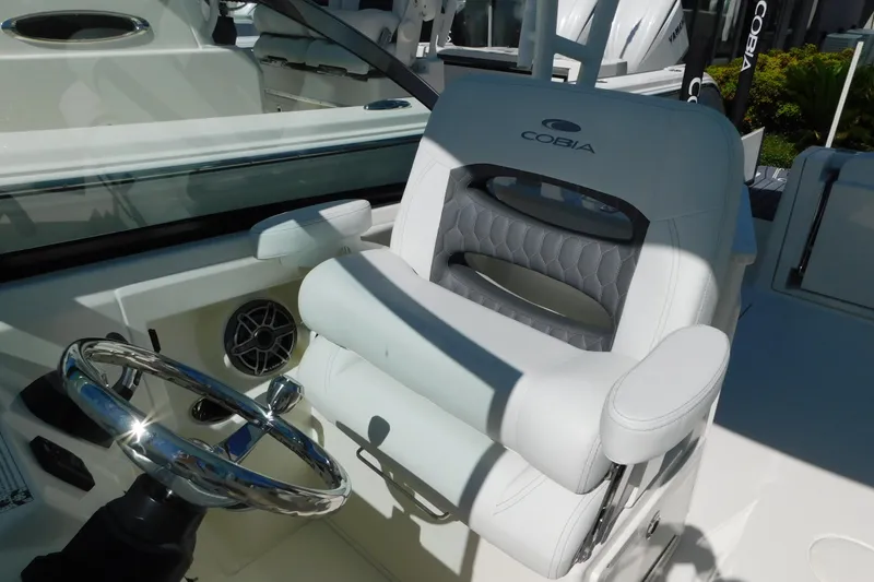 Slide: The Image of 2026 Cobia 240 Dual Console boat interior with cushioned seating and windshield. - 26