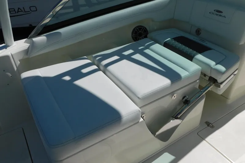Slide: The Image of 2026 Cobia 240 Dual Console boat seating with white cushions and adjustable backrest. - 36
