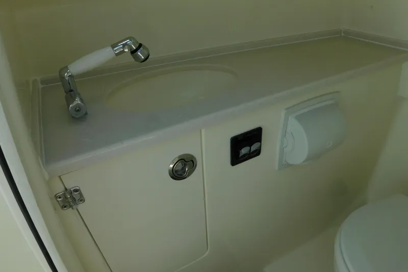 Slide: The Image of 2026 Cobia 240 Dual Console boat interior with white seating and speakers. - 40