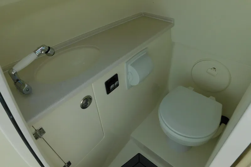 Slide: The Image of 2026 Cobia 240 Dual Console boat interior bathroom with toilet and sink. - 42