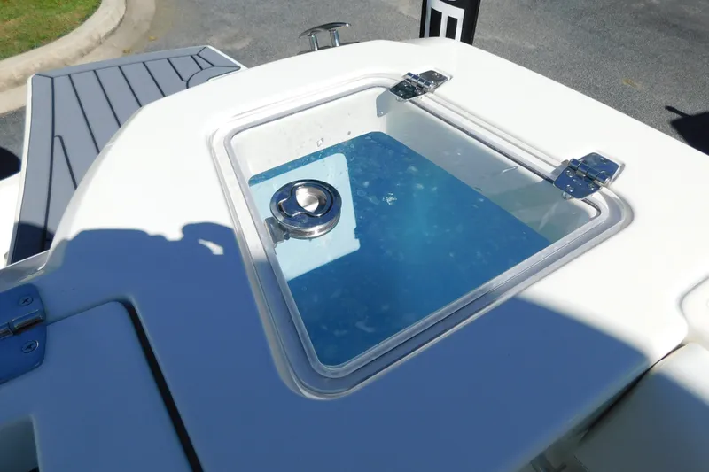Slide: The Image of 2026 Cobia 240 Dual Console boat storage compartment with white cushions. - 44
