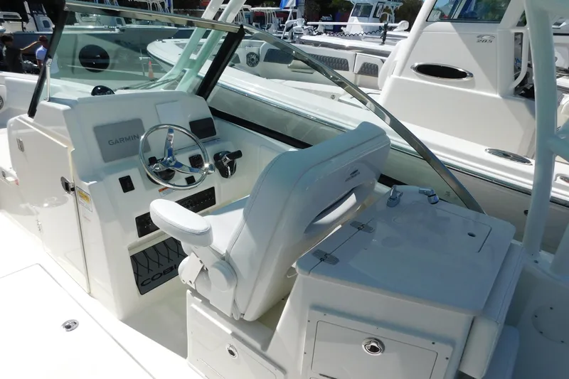 Slide: The Image of 2026 Cobia 240 Dual Console boat underside with speakers against clear blue sky. - 46