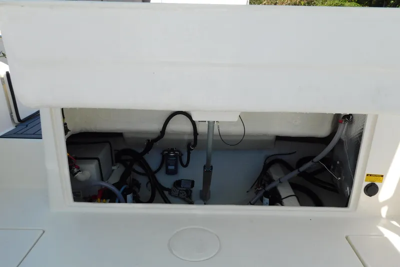 Slide: The Image of 2026 Cobia 240 Dual Console boat with ladder and trailer, rear view. - 54