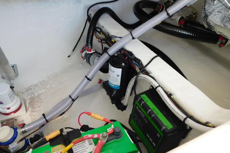 Slide: The Image of Engine compartment of 2026 Cobia 240 Dual Console with fuel and water systems. - 57