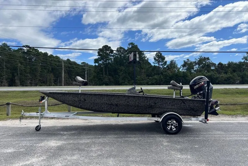 The Image of 2026 Xpress XP200 boat on trailer, parked outdoors under a partly cloudy sky. - 1