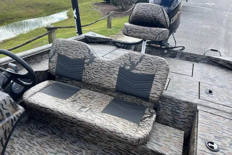 Slide: The Image of 2026 Xpress XP200 boat interior with camouflage seating and steering wheel. - 11