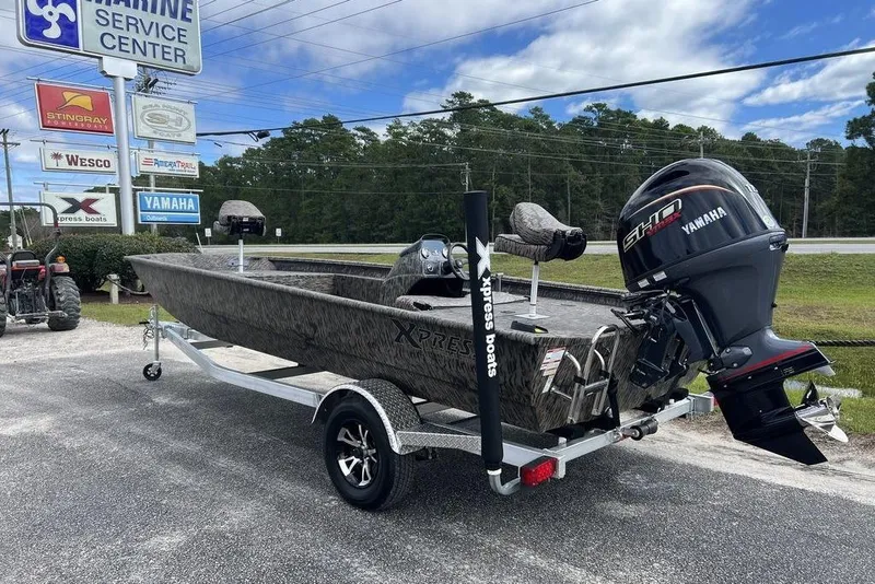 Slide: The Image of 2026 Xpress XP200 boat with Yamaha engine on trailer at marine service center. - 2