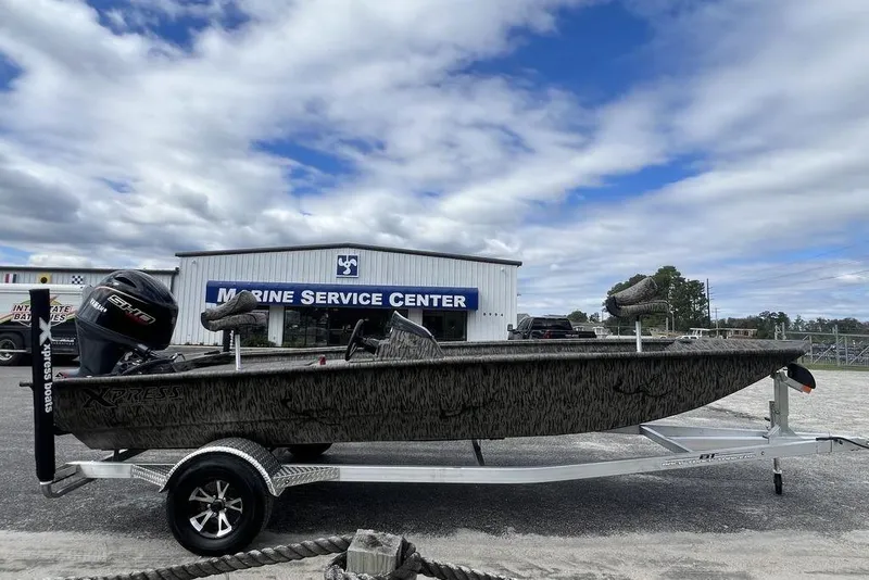 Slide: The Image of 2026 Xpress XP200 boat on trailer at Marine Service Center, under cloudy sky. - 3