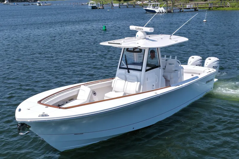 Slide: The Image of 2025 Regulator 31 boat cruising on a calm lake with dual engines. - 10