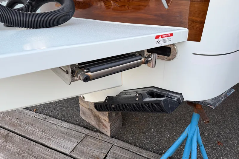 Slide: The Image of 2025 Regulator 31 boat detail showing hydraulic mechanism and warning label. - 17