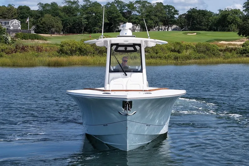 Slide: The Image of 2025 Regulator 31 boat cruising on a scenic waterway with lush greenery. - 2