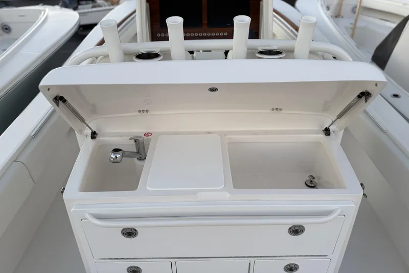 Slide: The Image of 2025 Regulator 31 boat sink and storage area with rod holders. - 23