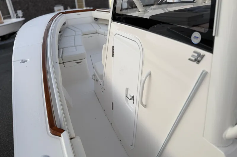 Slide: The Image of 2025 Regulator 31 boat interior with sleek white seating and polished wood accents. - 30