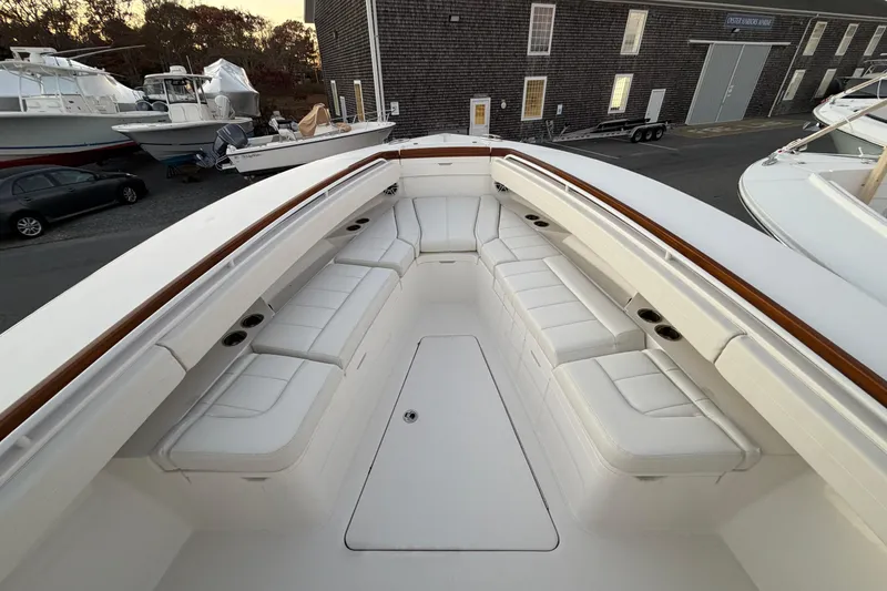 Slide: The Image of 2025 Regulator 31 boat with spacious white seating and wooden accents in a marina setting. - 31