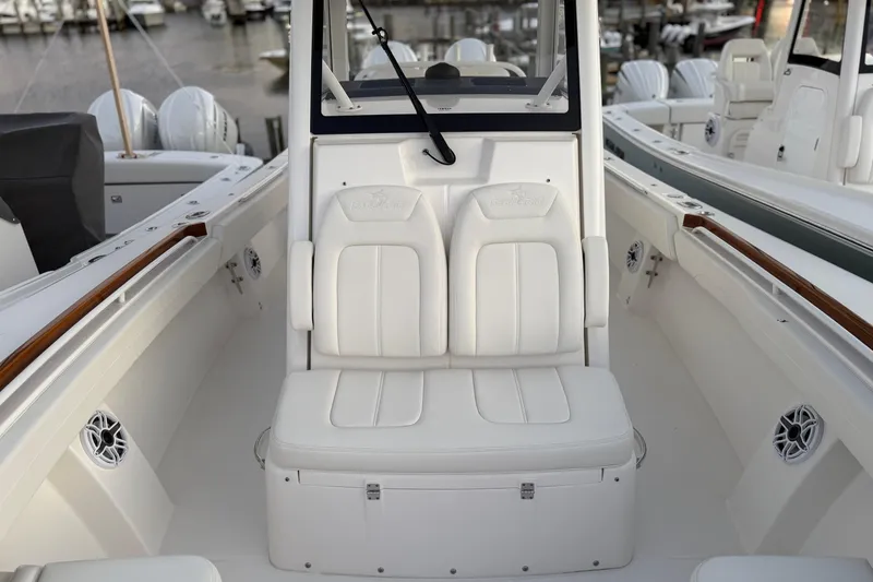 Slide: The Image of 2025 Regulator 31 boat interior with white seating and sleek design at a marina. - 39