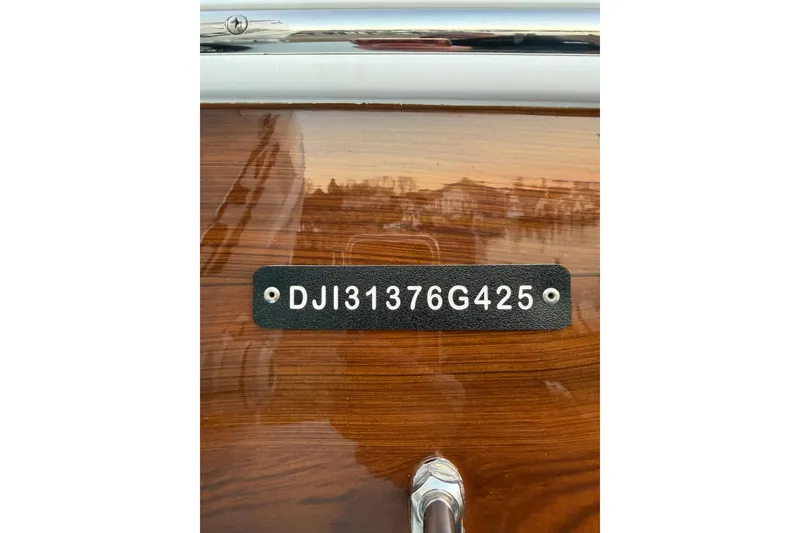 Slide: The Image of 2025 Regulator 31 boat with identification plate "DJI31376G425" on wooden surface. - 42