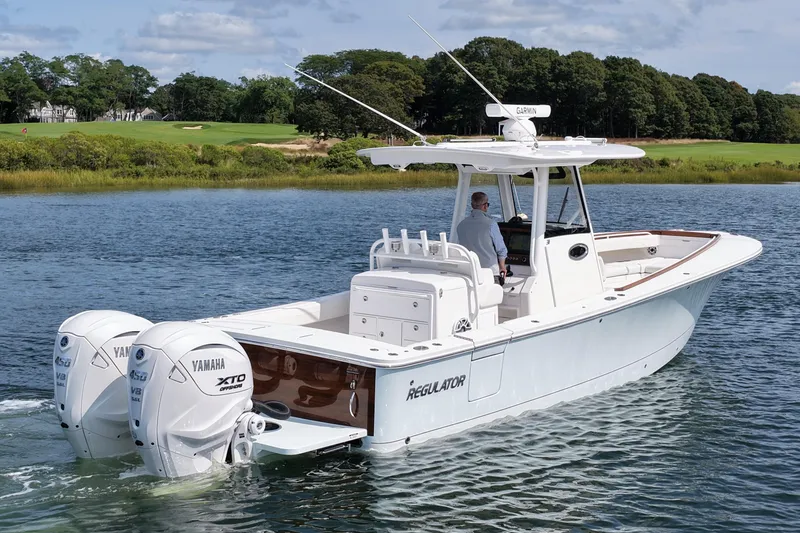 Slide: The Image of 2025 Regulator 31 boat with dual Yamaha engines on a serene waterway. - 6