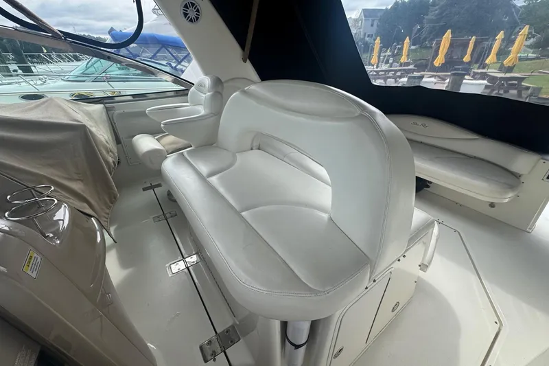 Slide: The Image of Interior of 2001 Sea Ray 410 Sundancer with white leather seating and covered controls. - 13