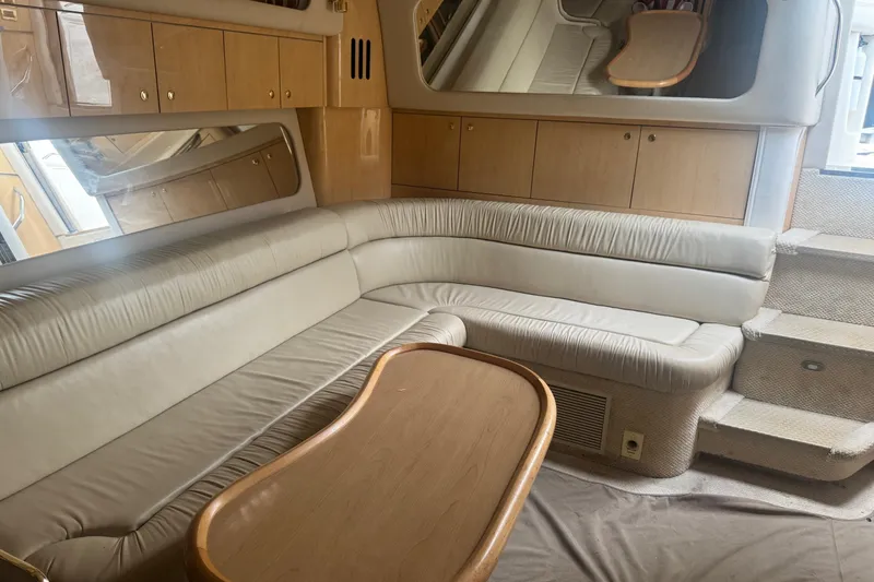 Slide: The Image of Luxurious interior of 2001 Sea Ray 410 Sundancer yacht with beige leather seating and wooden table. - 23