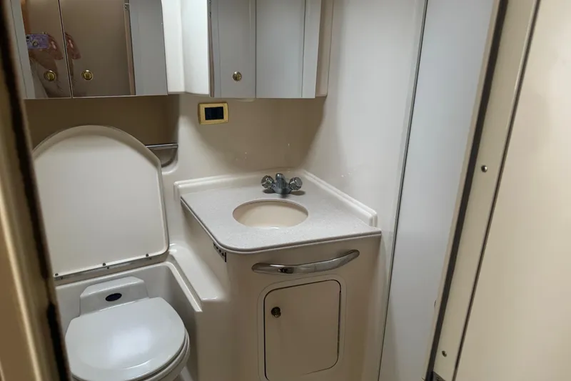 Slide: The Image of Bathroom interior of 2001 Sea Ray 410 Sundancer yacht, featuring sink and toilet. - 26