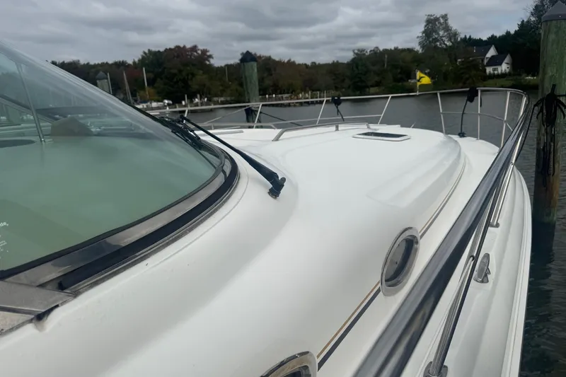 Slide: The Image of 2001 Sea Ray 410 Sundancer yacht docked by a serene waterfront. - 3