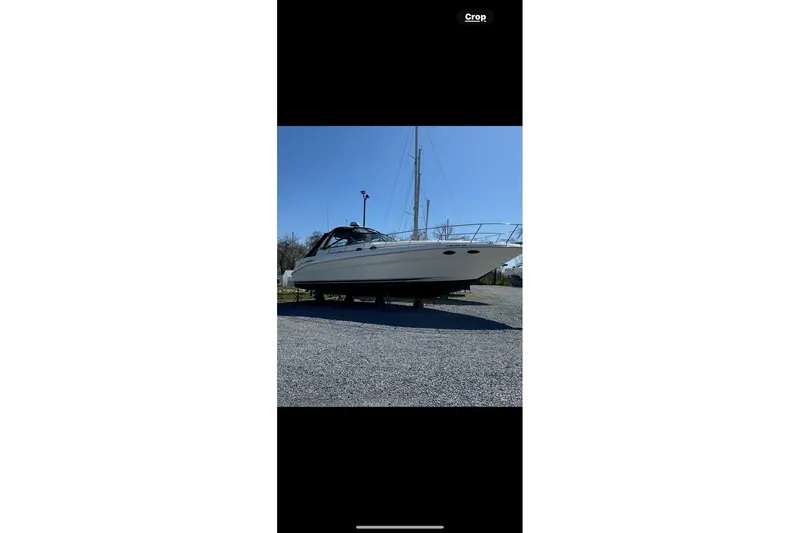 Slide: The Image of 2001 Sea Ray 410 Sundancer yacht on gravel, side view under clear sky. - 8