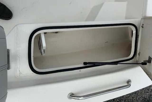 Slide: The Image of Open storage compartment on 2023 May-Craft 22 Handcock boat, featuring a sleek handle design. - 7