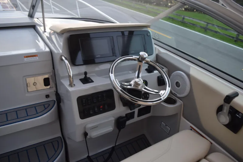 Slide: The Image of 2021 Regal 26 XO boat helm with steering wheel and control panel. - 101