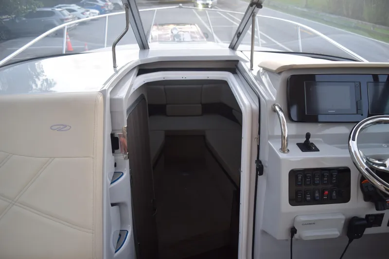 Slide: The Image of 2021 Regal 26 XO boat interior with helm, steering wheel, and cabin entrance. - 104