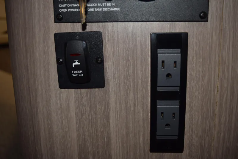 Slide: The Image of Switch and outlets on a 2021 Regal 26 XO boat interior panel. - 120