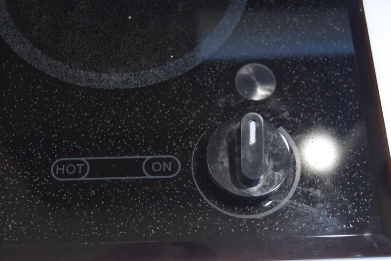 Slide: The Image of Control knob on a black speckled stovetop, labeled "HOT" and "ON." - 130