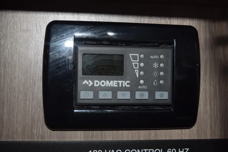 Slide: The Image of Dometic control panel in 2021 Regal 26 XO boat, mounted on wooden surface. - 131