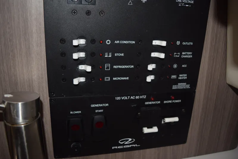 Slide: The Image of Control panel of a 2021 Regal 26 XO boat, featuring switches for various appliances. - 133