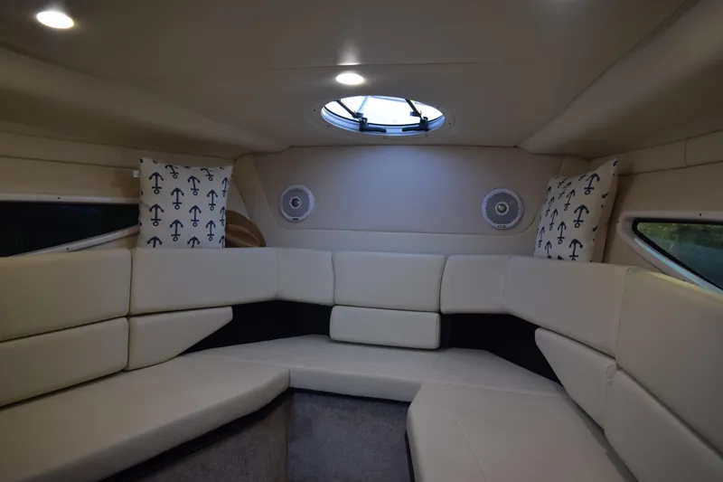 Slide: The Image of 2021 Regal 26 XO boat interior with beige seating and anchor-themed pillows. - 136