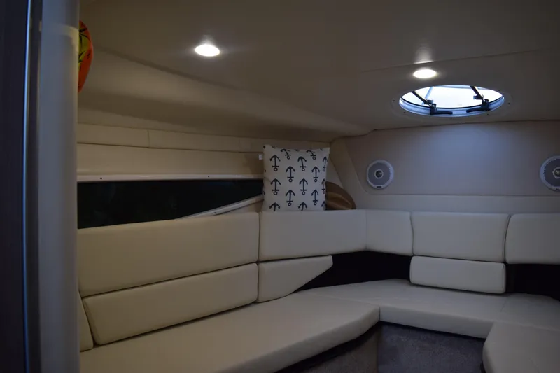 Slide: The Image of Interior of 2021 Regal 26 XO boat with beige seating and anchor-themed pillow. - 137