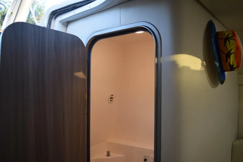 Slide: The Image of 2021 Regal 26 XO boat interior with open door and colorful hat on wall. - 142