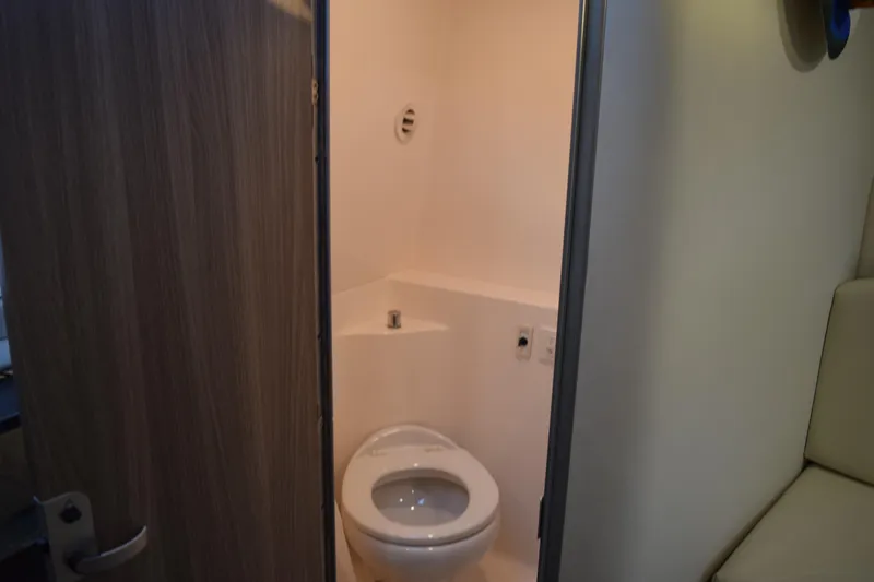 Slide: The Image of 2021 Regal 26 XO boat interior bathroom with toilet and wooden door. - 143